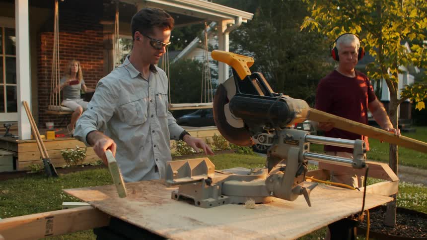 Two men working in a backyard with a circular saw