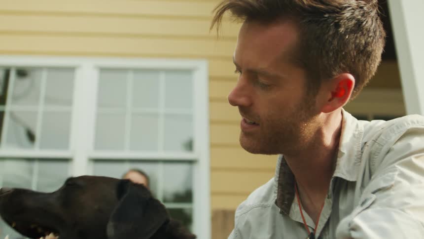 Man petting a black dog