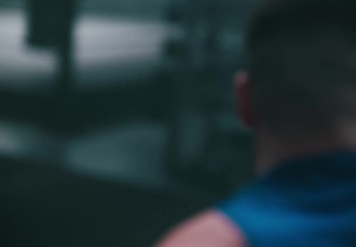 A man is working out in the gym swinging a hammer