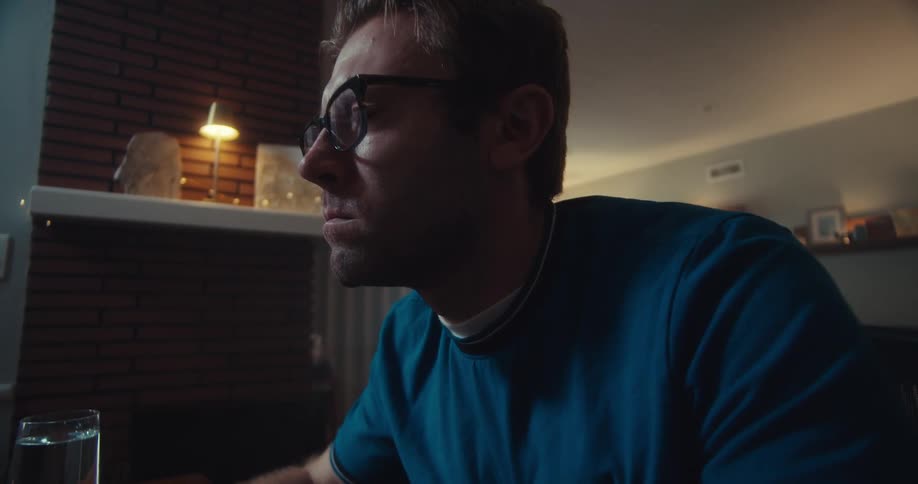 Man looks at falling stock prices on his computer screen appearing shocked worried and sad