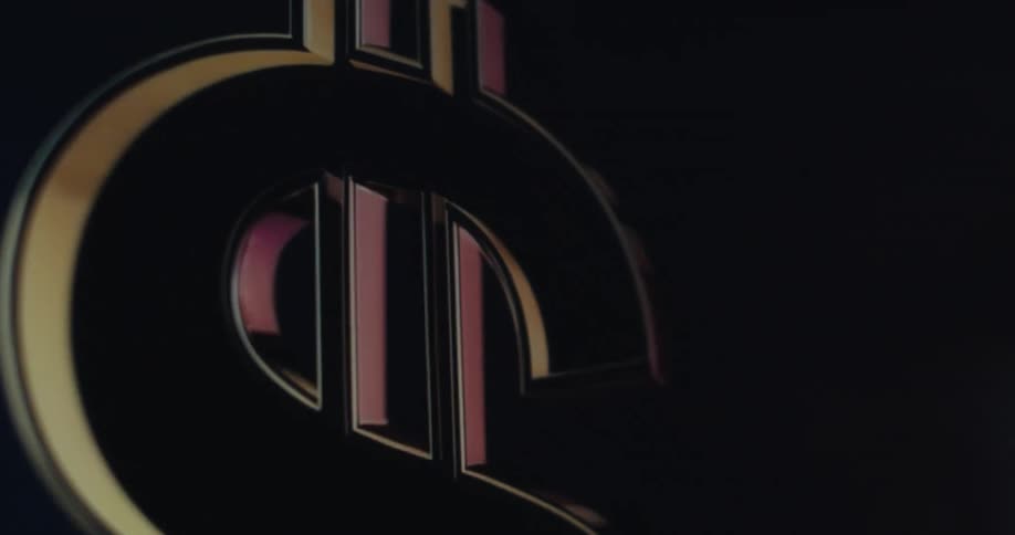 A large metallic gold dollar sign spins reflecting colors against a dark blue background
