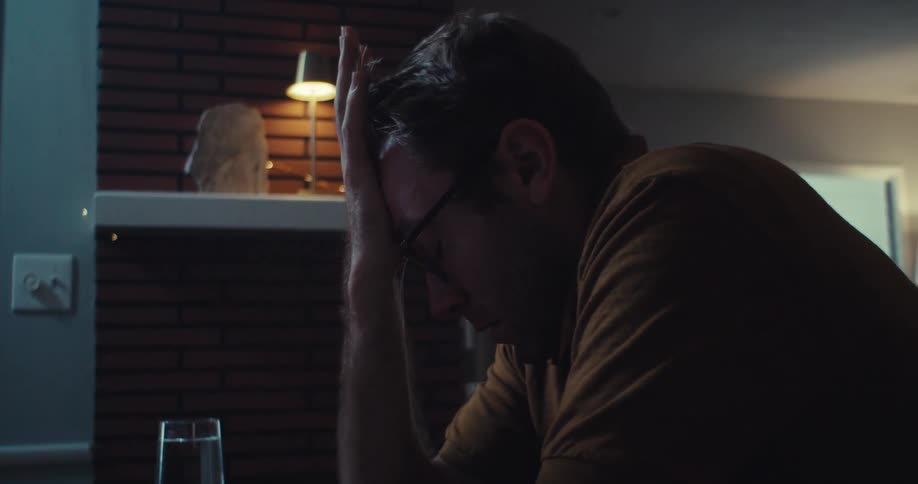 A worried man looking at a binary options chart on his computer