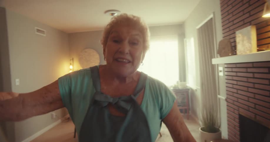 A woman is smiling and dancing in her living room