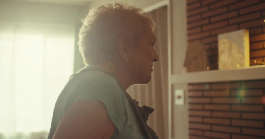 A joyful elderly couple dances in sync inside their home