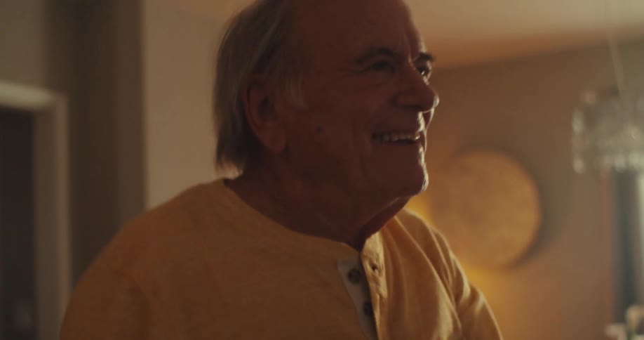 A happy elderly couple dancing in their living room