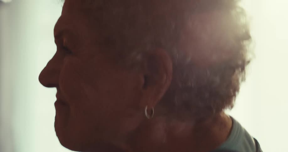 An elderly couple dancing in a sunlit room