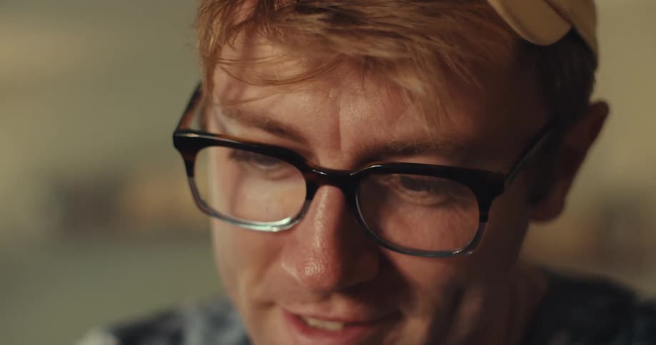 Close up of a man happily solving a rubiks cube in a room