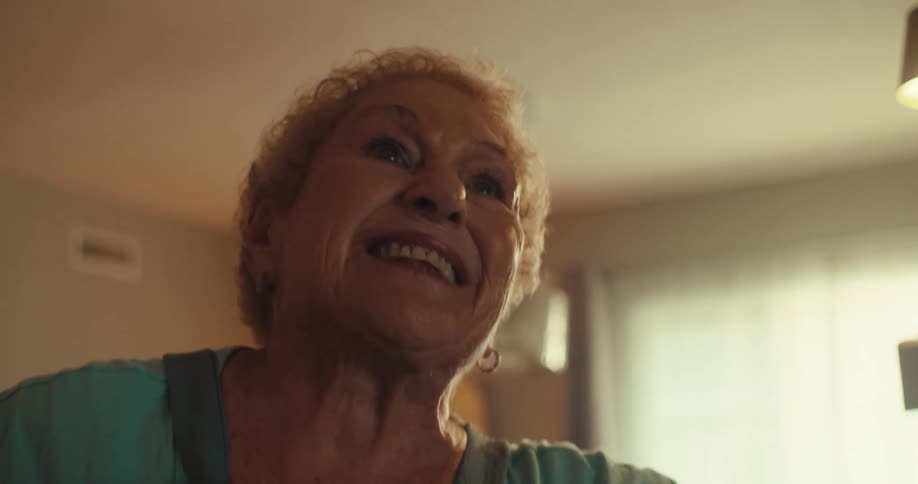 An elderly couple dancing inside their home