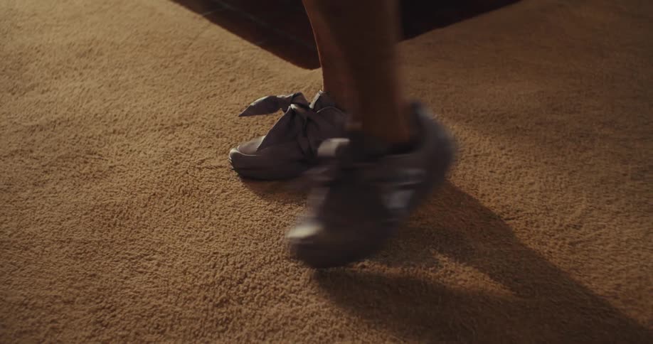 Legs of two people dancing on the rug indoor with shoes on