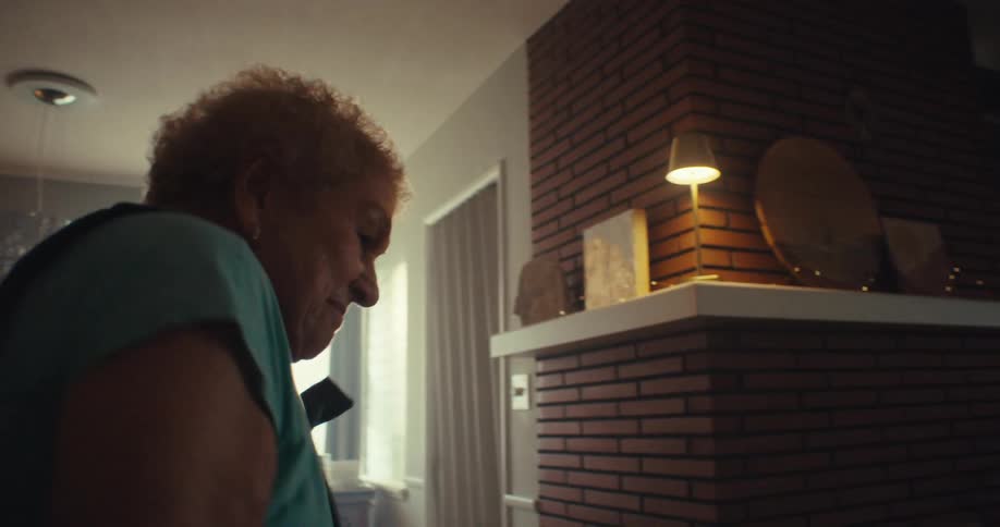 An elderly woman dances joyfully indoors clearly enjoying the moment