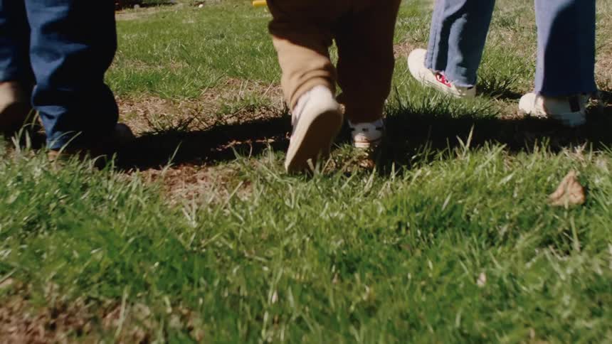 Three people walking together on the grass