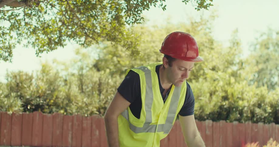 A man drinks from a cup and walks out of the yard