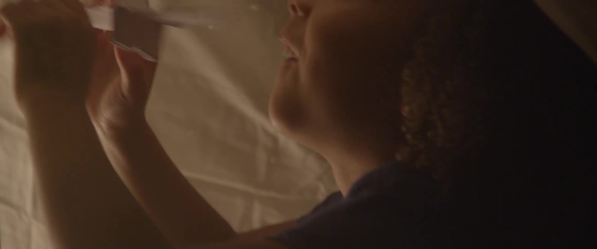 Child playing with hanging paper origami cranes