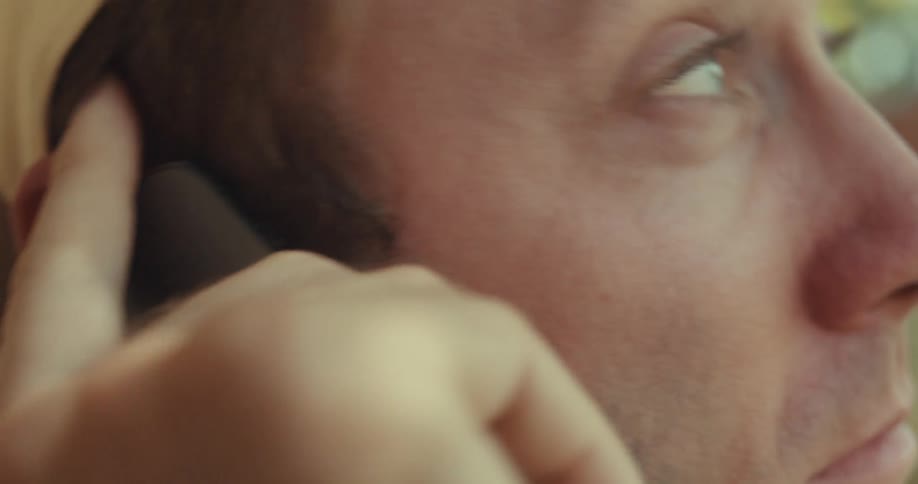 A man smiling and talking to someone on the phone