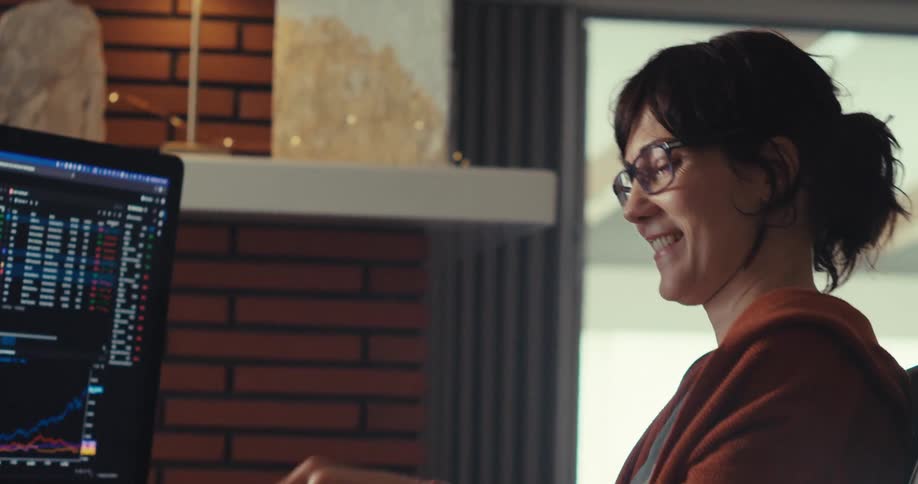 A woman writes something down and raises her arms happy