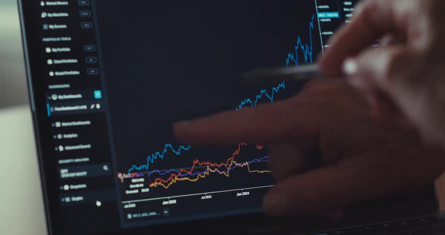 Two people point at the plot displayed on a laptop while collaborating