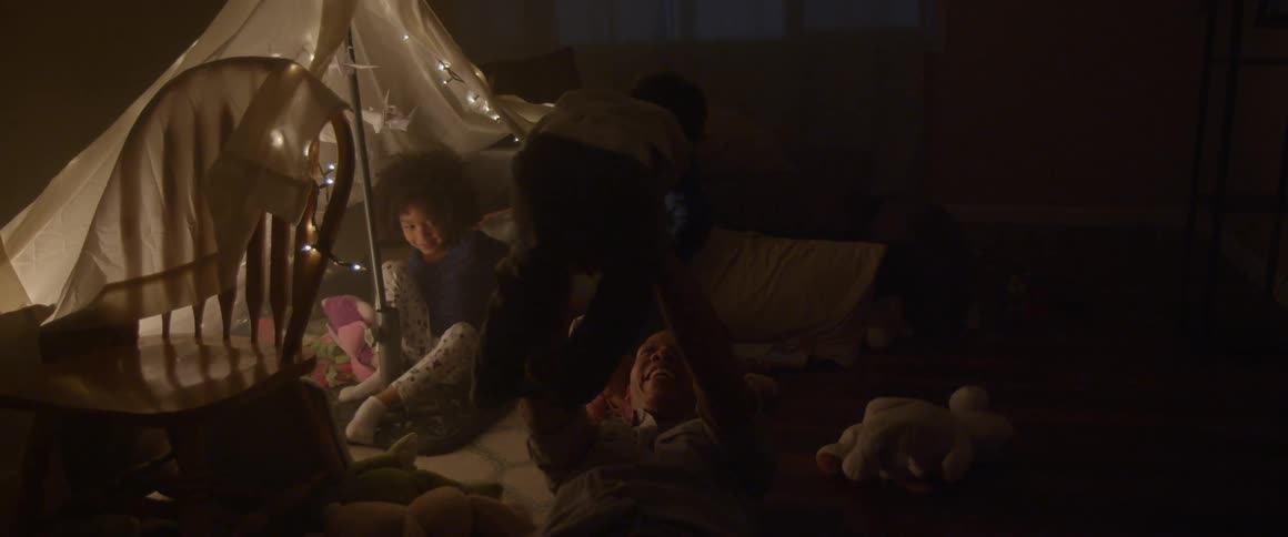 A woman and some children play near a tent