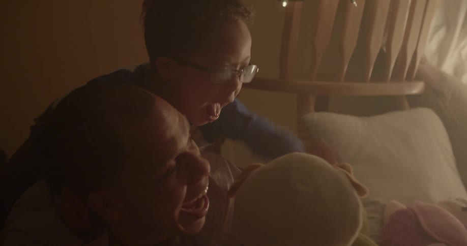 A man and young boy play with a stuffed animal