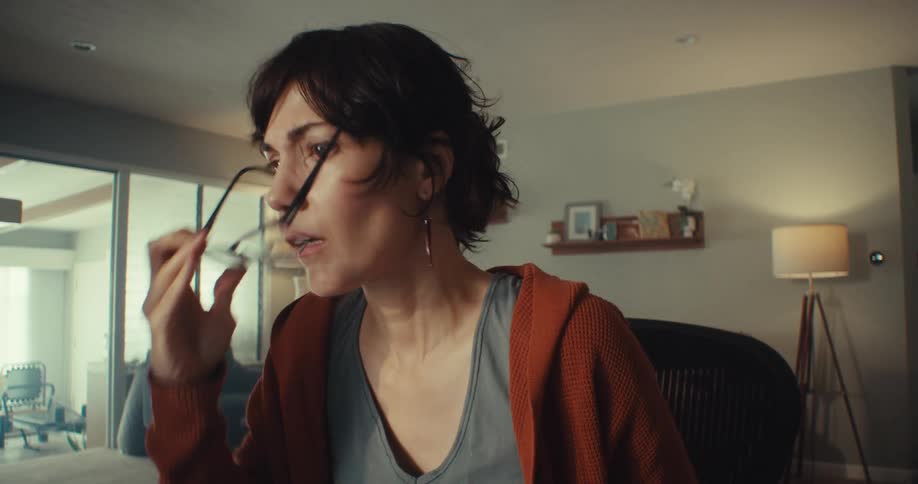A woman is afraid and takes her glasses off