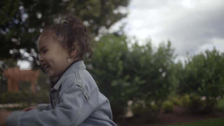 Daughter chases the bubbles blown by her mother while playing outdoors