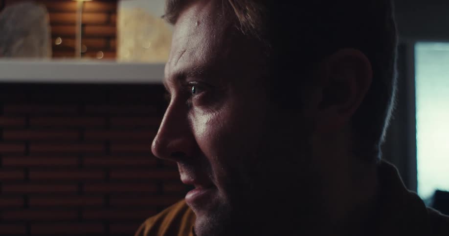 A man leans forward looking at a stack of cards