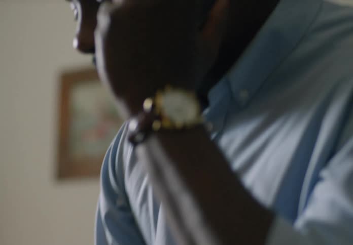 A man is picking up medicine from a table while talking on the phone