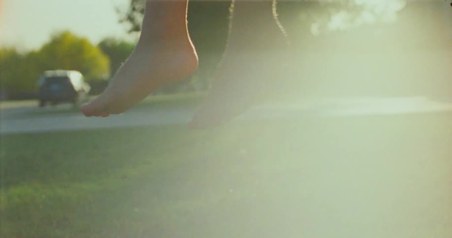 A persons feet are hanging above the grass