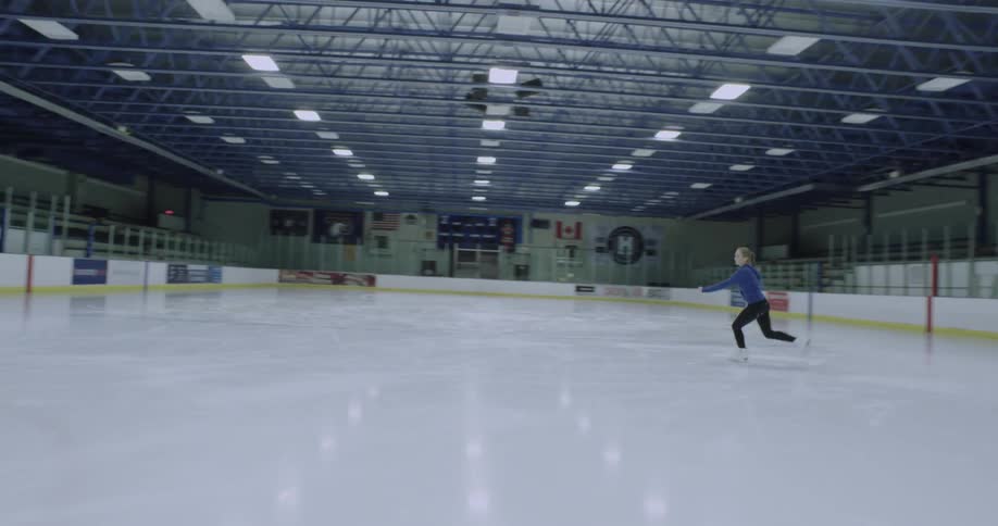 A girl does a jump on her ice skates