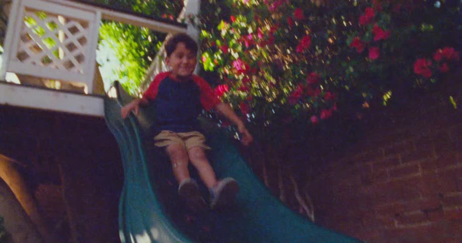 A boy slides down the slide