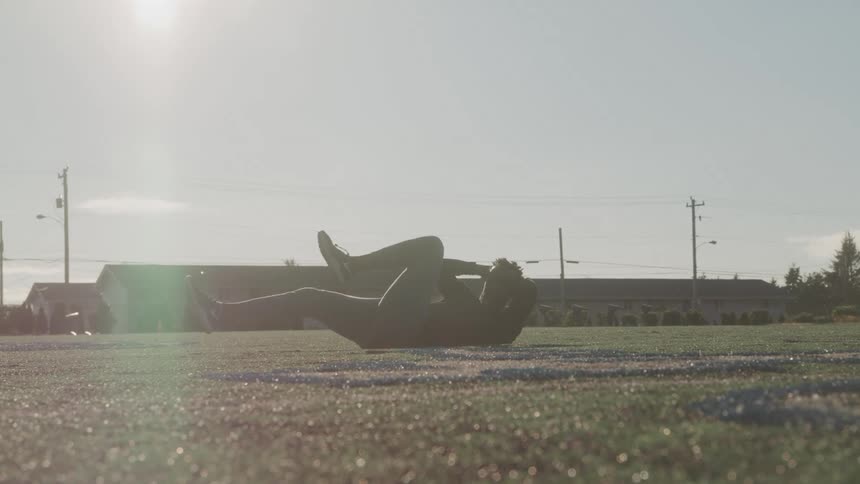 A man is working out on the grass