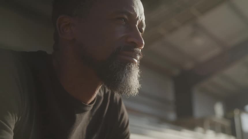 A man sitting outside looks up