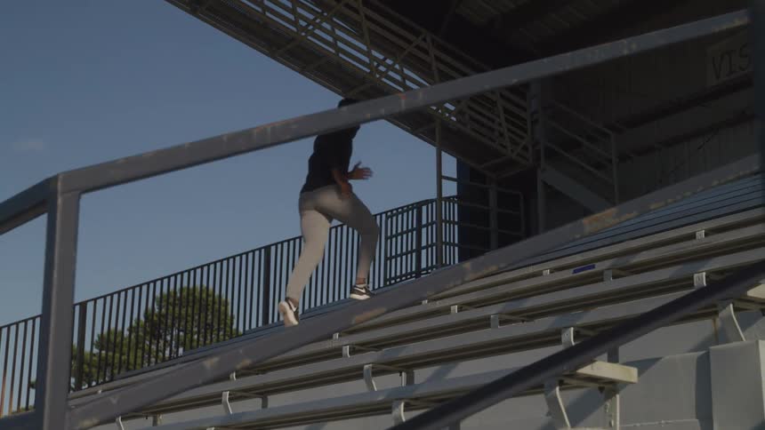 Man running up the metal stairs of a grandstand