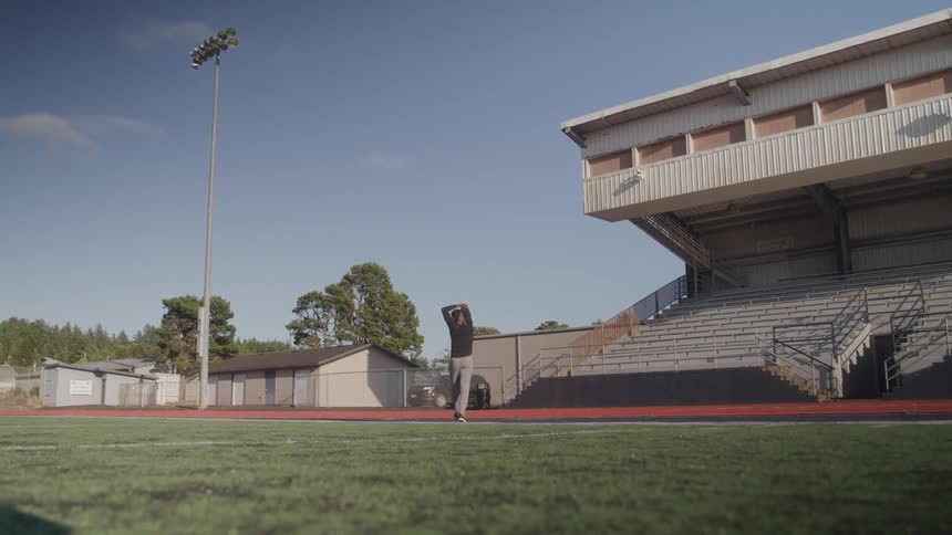 A man is walking on the football field