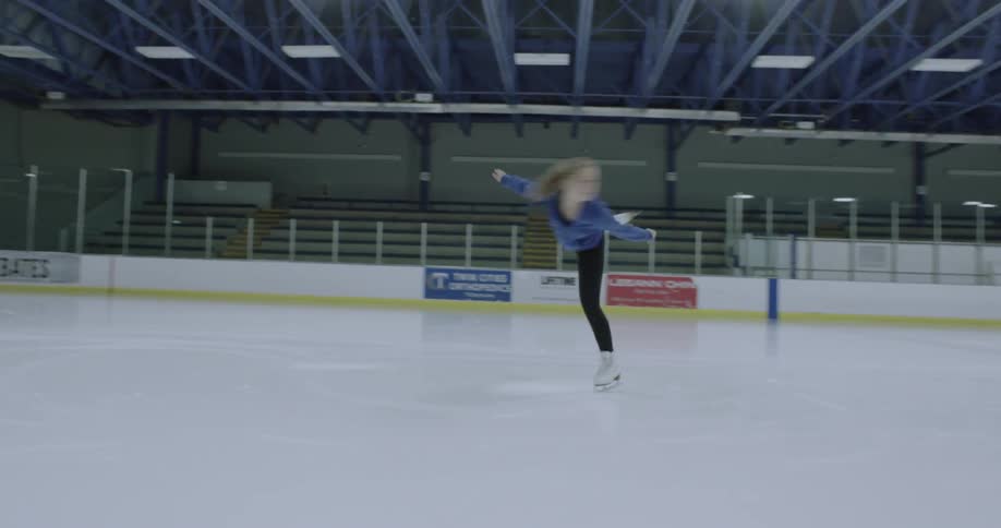 A woman is doing twirls on an ice rink
