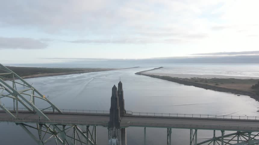 Aerial shot of a metal bridge over the ocean at dawn