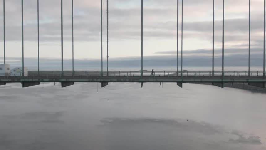 A man jogs along the long bridge