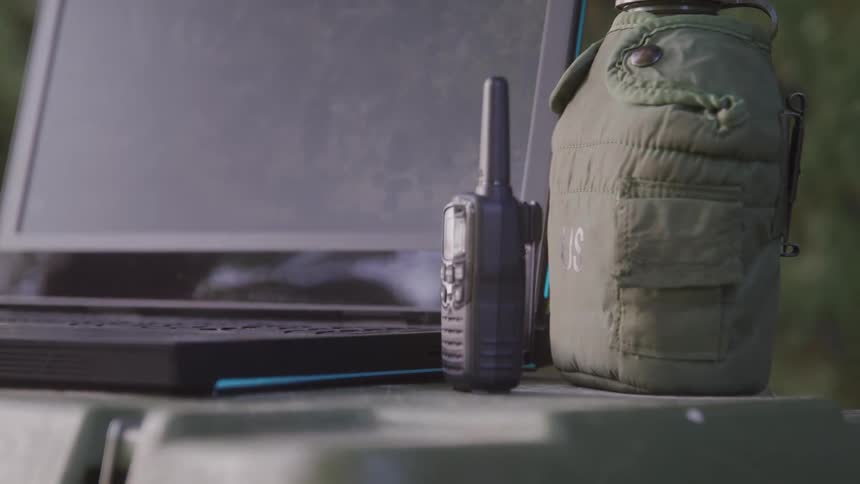 A walkie talkie sits by the laptop