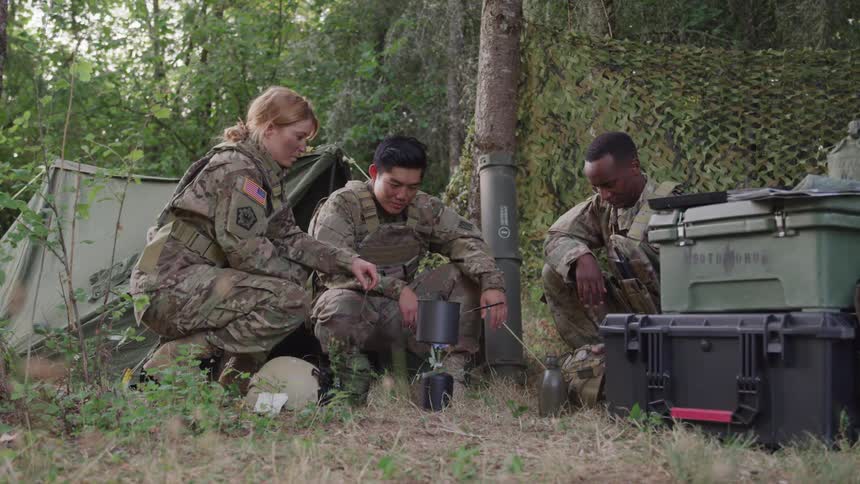 Three soldiers are cooking at their camp