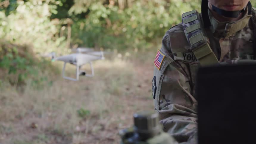 The soldier is flying a drone
