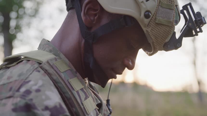 The soldier is looking down outside