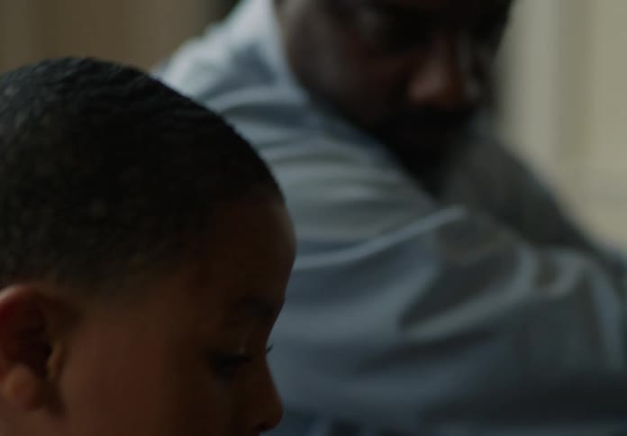 Father and son sitting indoors