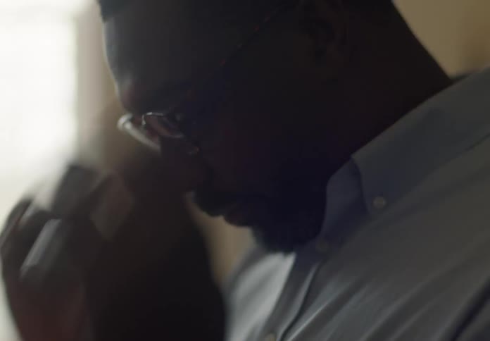 A man saying something and then putting on glasses