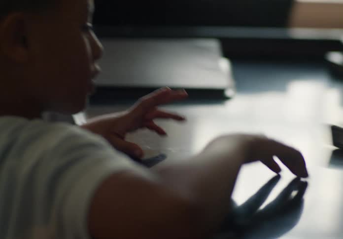 A boy helps an adult organize folders and shares a fist bump after completing the task