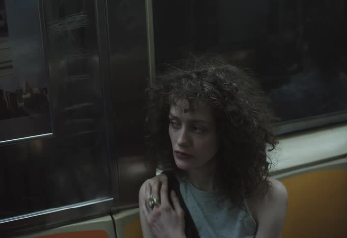 Woman rides a train that passes into a tunnel during the daytime