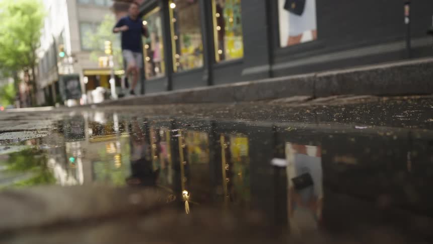 Person running on sidewalk outdoors through city