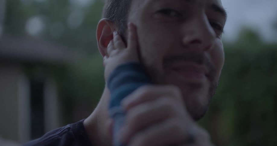 A person with a beard smiles at the camera while a child plays with his ear