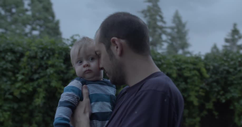 A man lovingly holding a baby in his arms