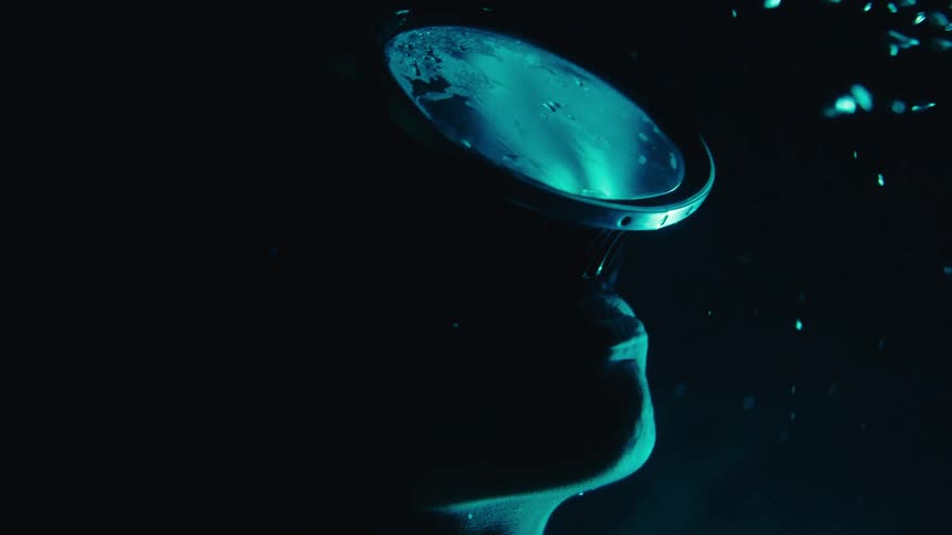 A woman swimming underwater in the sea heading to the surface