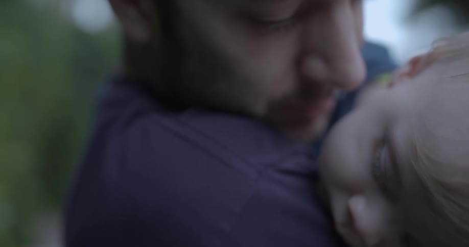 A father is hugging his son outside