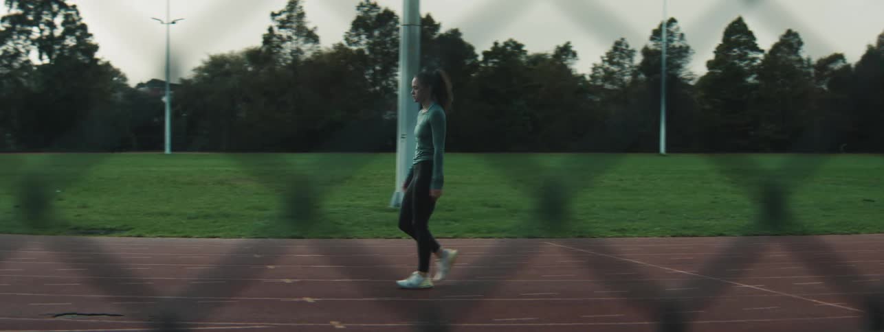 A woman is walking on the running track